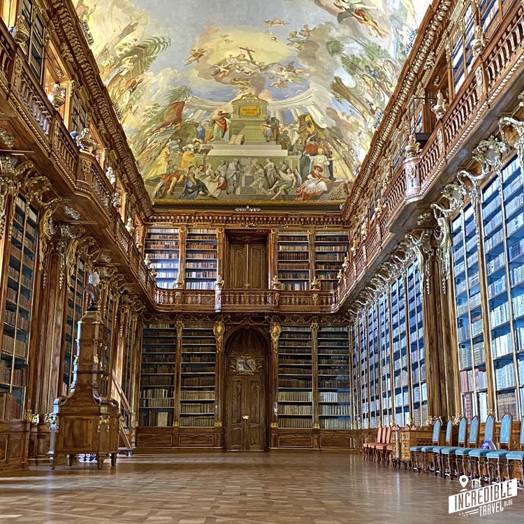 Blcik in den alten Bibliothekssaal mit Deckenfresken und etwa sechs Meter hohen Wänden voller alter Bücher