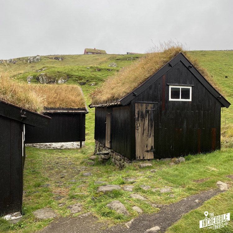 Kleine schwarze Holzhäuser mit Grasdächern