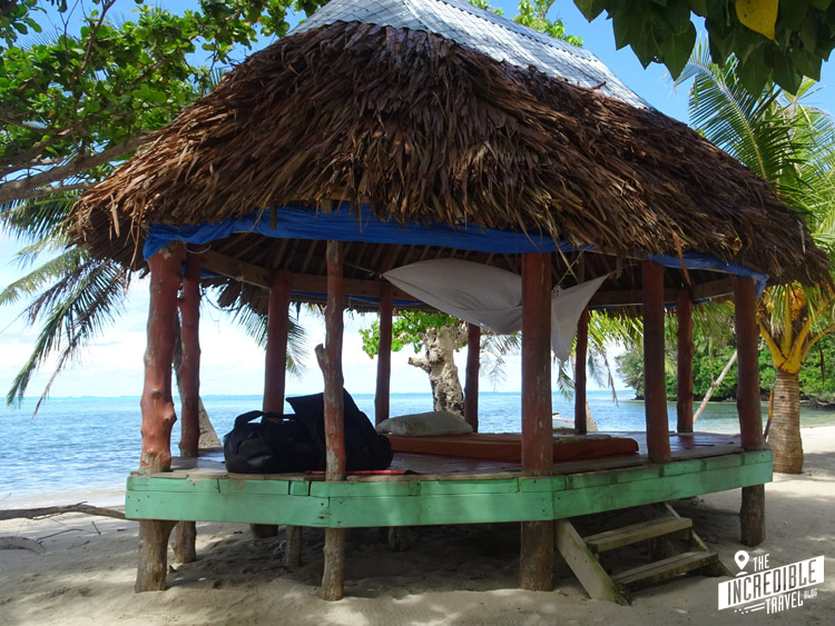 Offener Pfahlbau mit Matratze und Dach aus Palmenblättern direkt am Meer