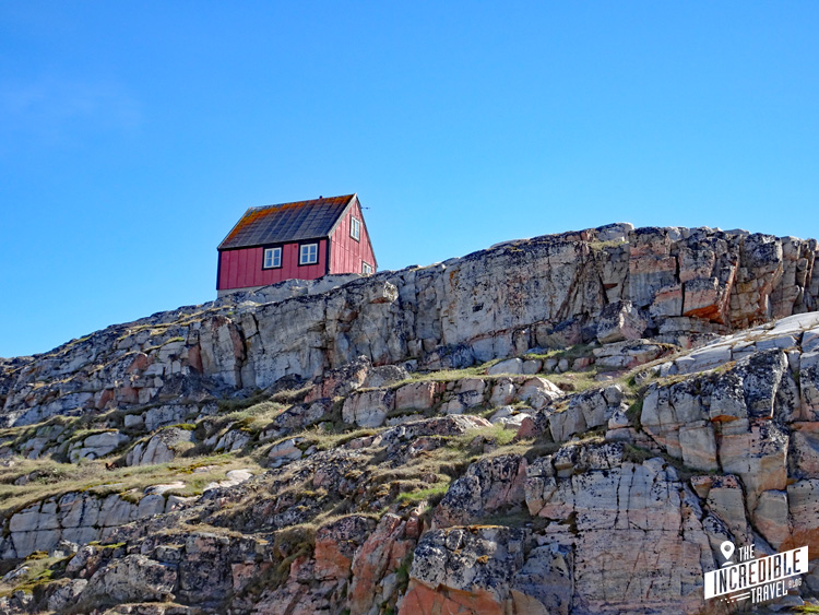 Einsames rotes Haus auf einem Felsen