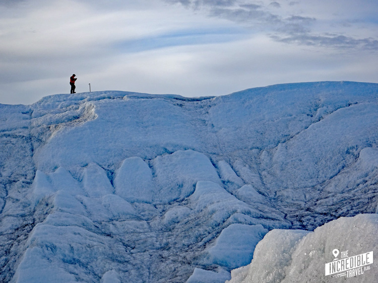 Kleiner Mann steht in der Entfernung auf einem Eisberg