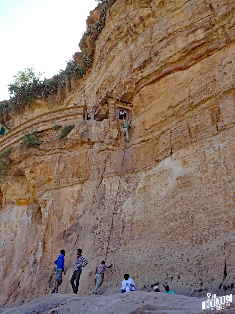 Tourist wird an einem Seil an der Steilwand eines Berges hochgezogen