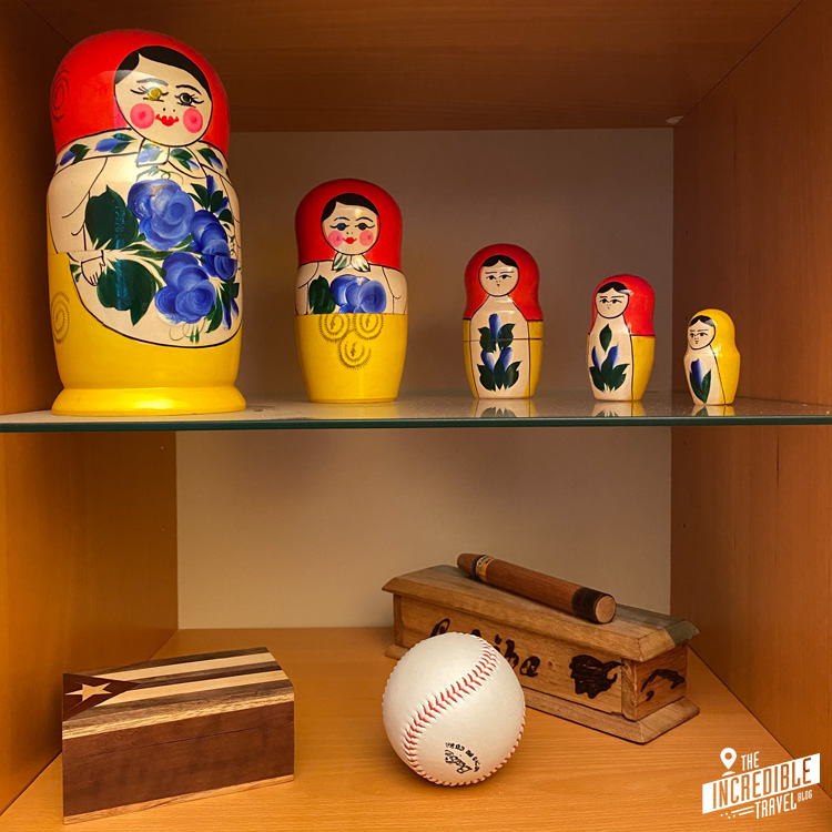 Blick in ein Regal mit russischen Figuren, einem Baseball und Kistchen