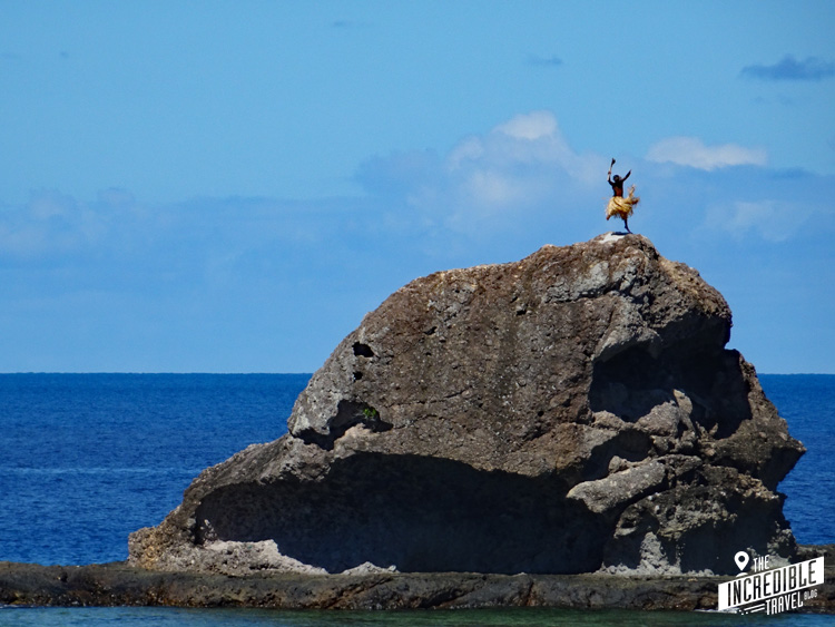 Mann tanzt in Palmenblätter-Rock auf einem Felsen