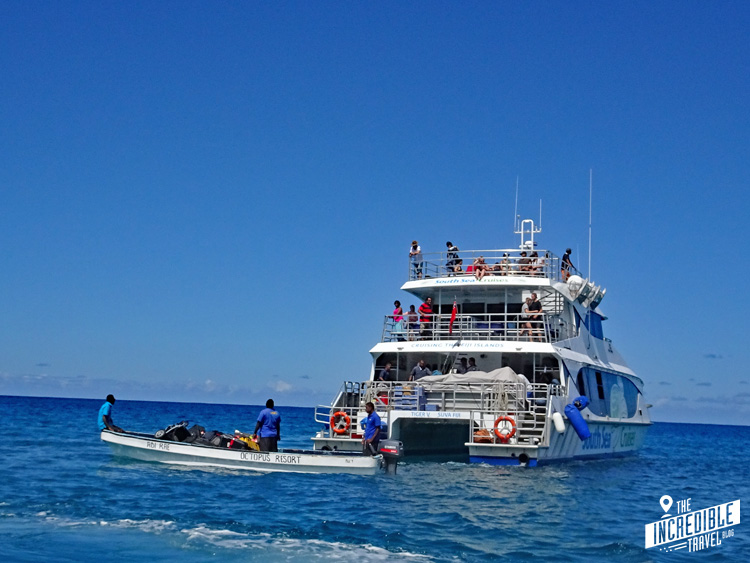 Großer Katamaran hält auf offener See, um Fahrgäste auf kleinere Boote umsteigen zu lassen