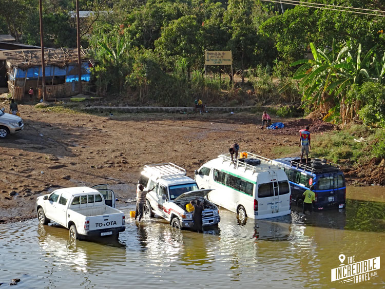 Autos werden ins flache Wasser des Flusses gefahren und dort gewaschen