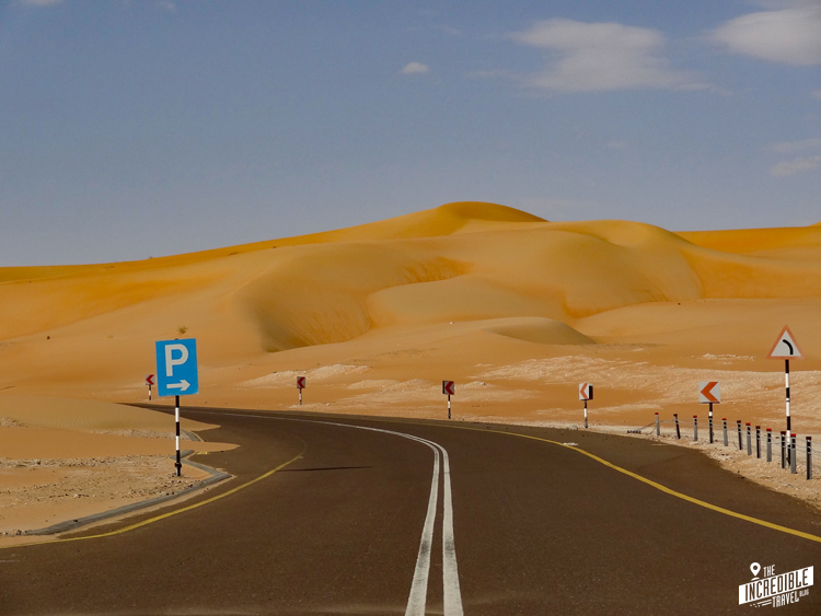 Asphaltierte Straße führt durch Sanddünen