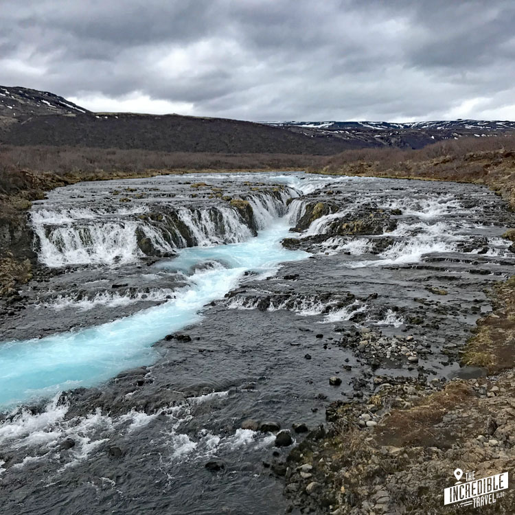 Hufeisenförmifger Wasserfall mit scheinbar hellblauem Wasser