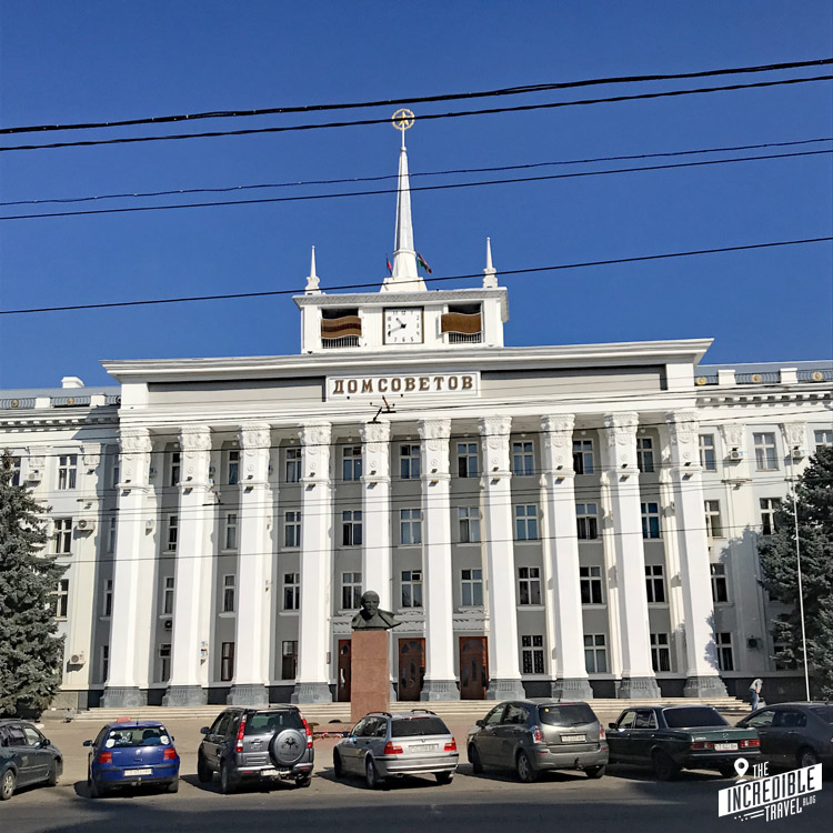 Großes weißes Gebäude mit Lenin-Statie und Sowjetstern