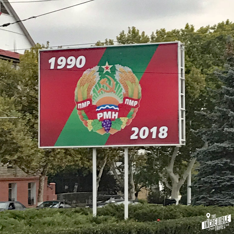 Schild mit den Jahreszahlen 1990 und 2018, Staatsemblem mit Hammer und Sichel
