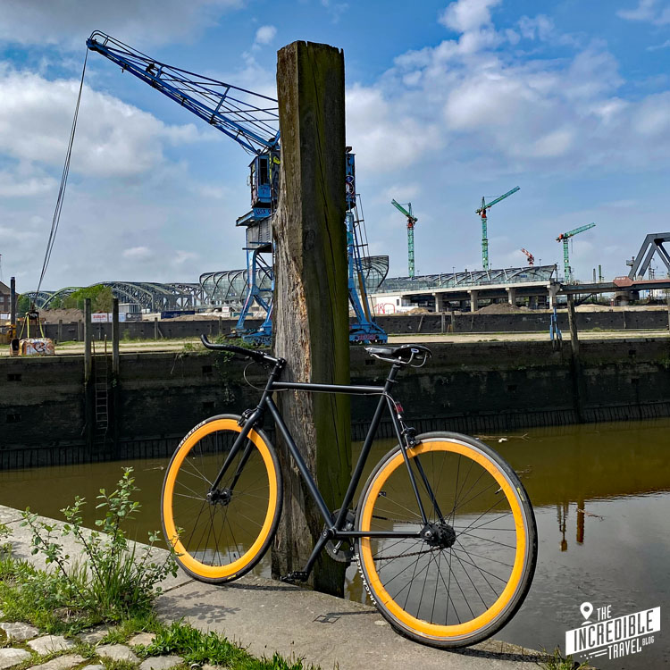 Fahrrad am Hafenbecken, im Hintergrund ein alter Kran