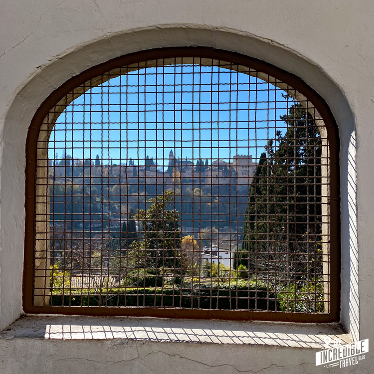 Blick auf die Alhambra durch einen vergittertes Steinbogen
