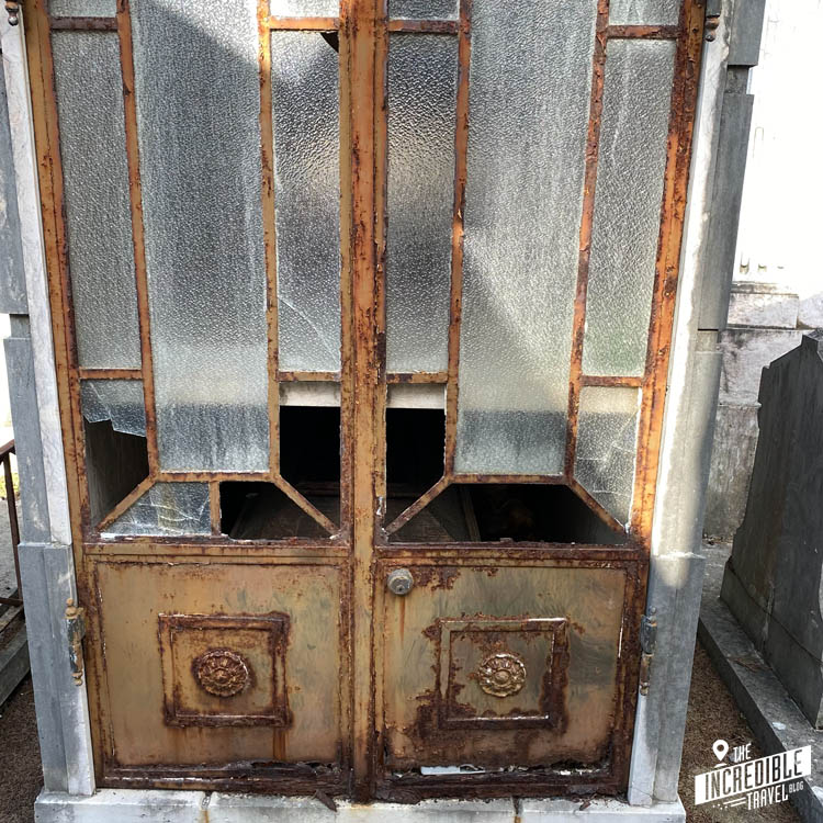 Zerbrochene Scheiben in der Tür einer Grabstätte