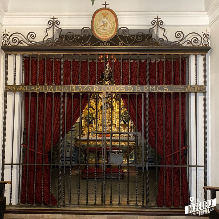 Blick durch ein Gitter und einen roten Samtvorhang in eine kleine Kapelle