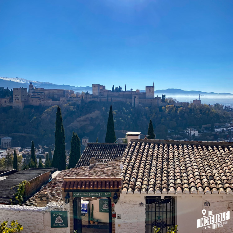 Ansicht der Alhambra, im Vordergrund der Eingang zu einem Restaurant