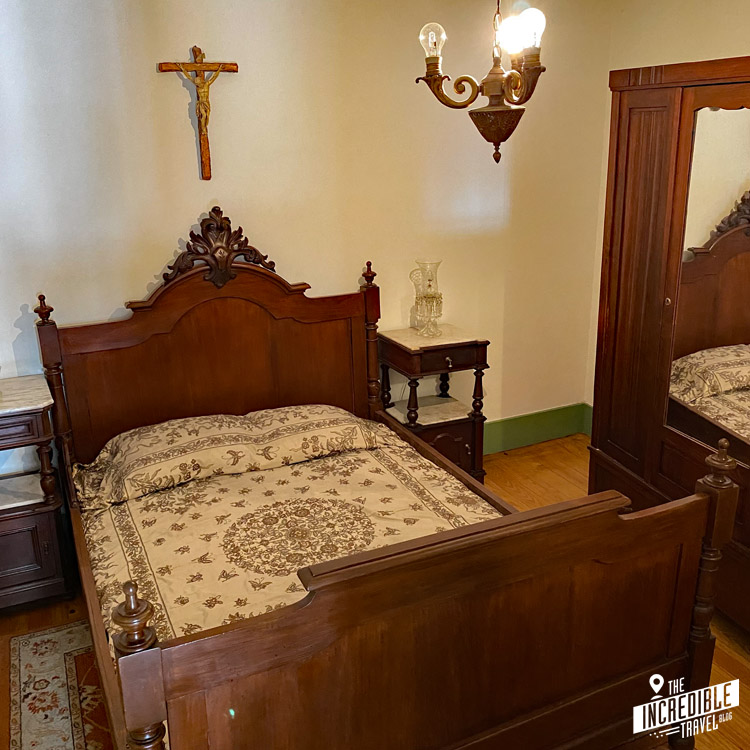Bett mit Nachttischen und Kruzifix im Versteckten Haus