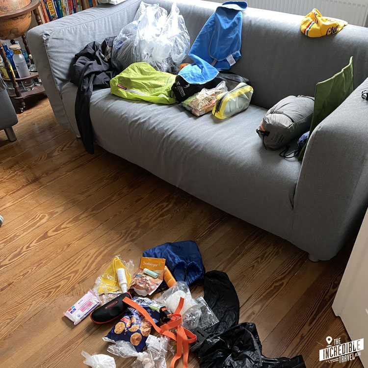 Durcheinander auf Sofa und Fußboden mit Ausrüstungsgegenständen