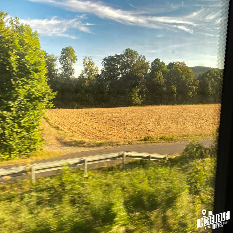 Foto aus dem Zug heraus auf ein Feld und einen Feldweg
