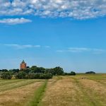 Panorama von Feldern mit dem Neuwerker Leuchtturm