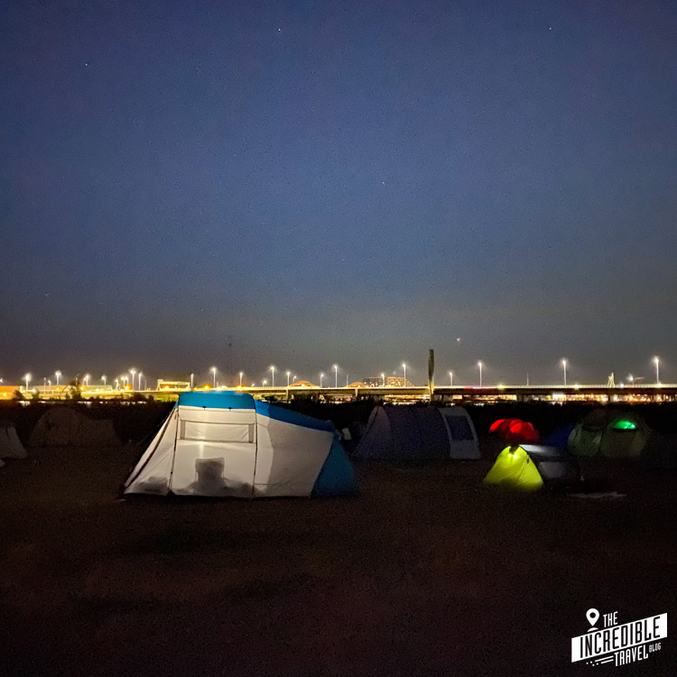 Nachtansicht des Campingplatzes mit ein paar von innen erleuchteten Zelten