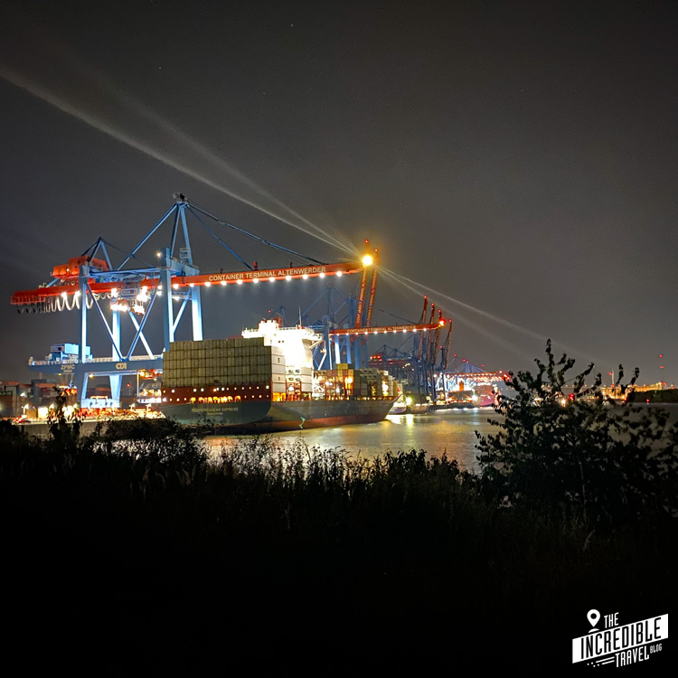 Containerterminal und Containerschiff bei Nacht