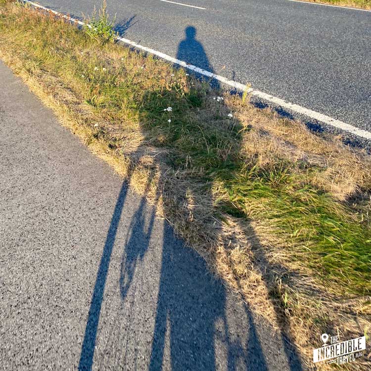 Schatten von Fahrrad und Fahrer auf Radweg und Straße