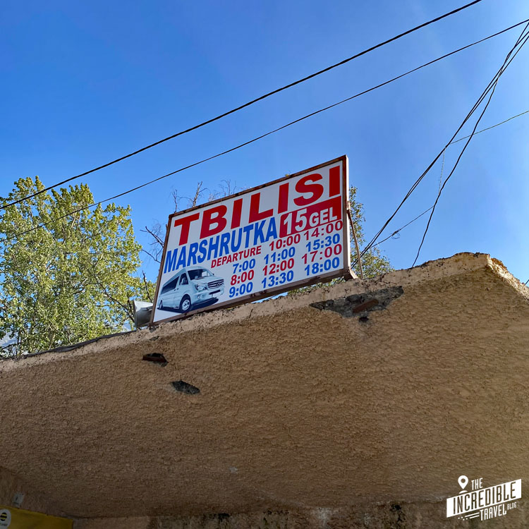 Schild auf einer Betonplatte mit Abfahrtszeiten der Marshrutkas nach Tbilisi