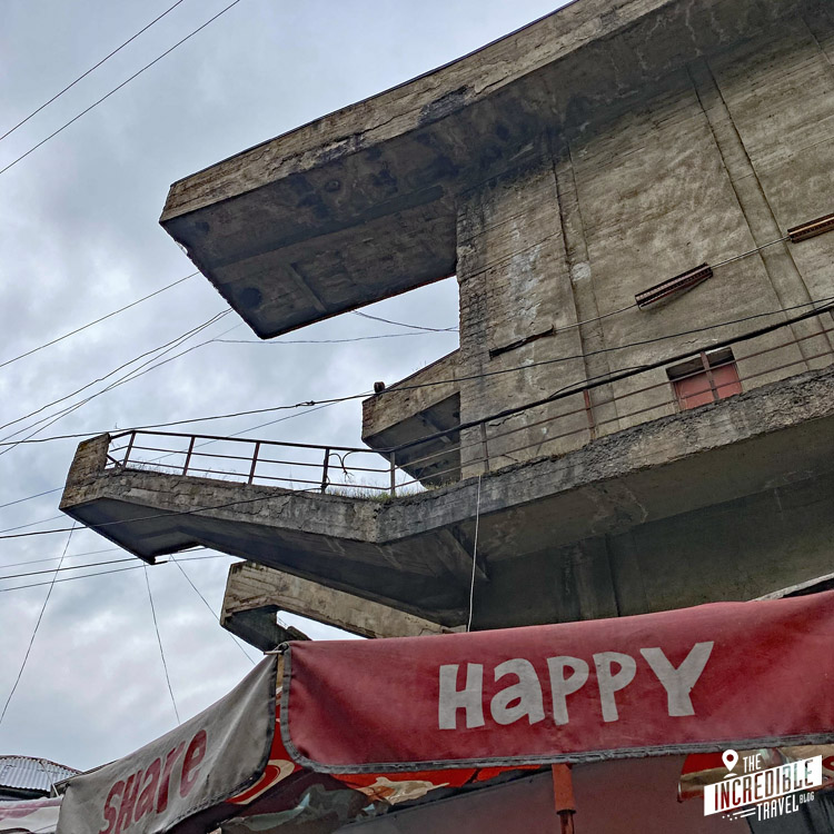 Stillgelegte Seilbahnstation, davor ein Schirm mit der Aufschrift "Happy"