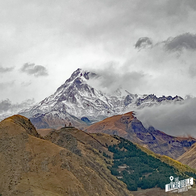 Blick auf den wolkenverhangenen Mount Kasbek und die Dreifaltigkeitskirche