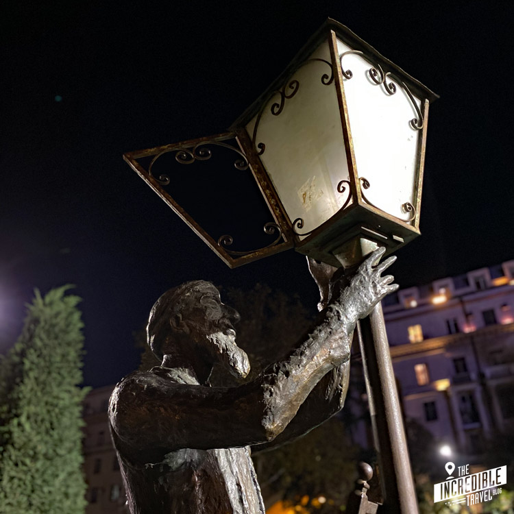 Statue eines Nachtwächters, der eine Lampe anzündet