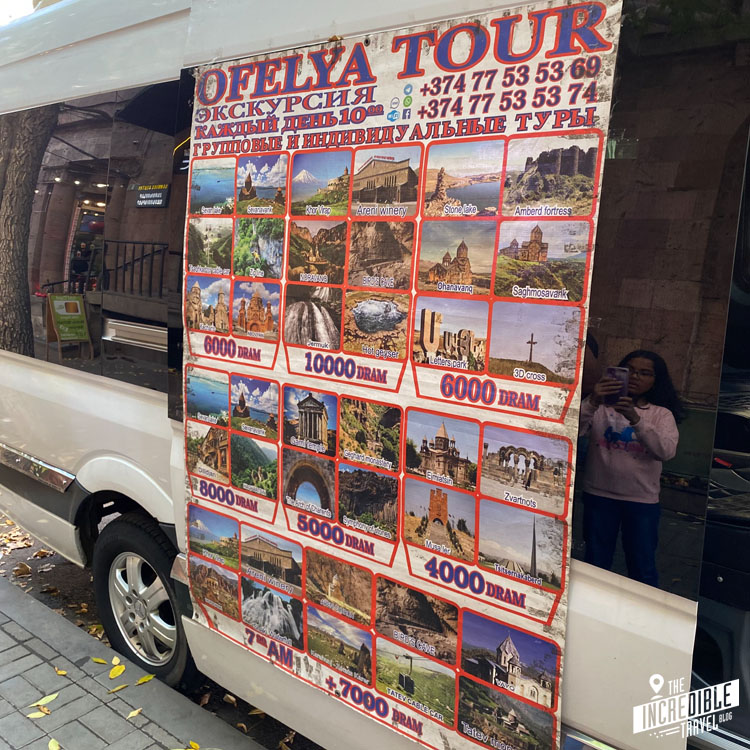 Plakat an einem Minivan mit zahlreichen Angeboten für Tagestouren
