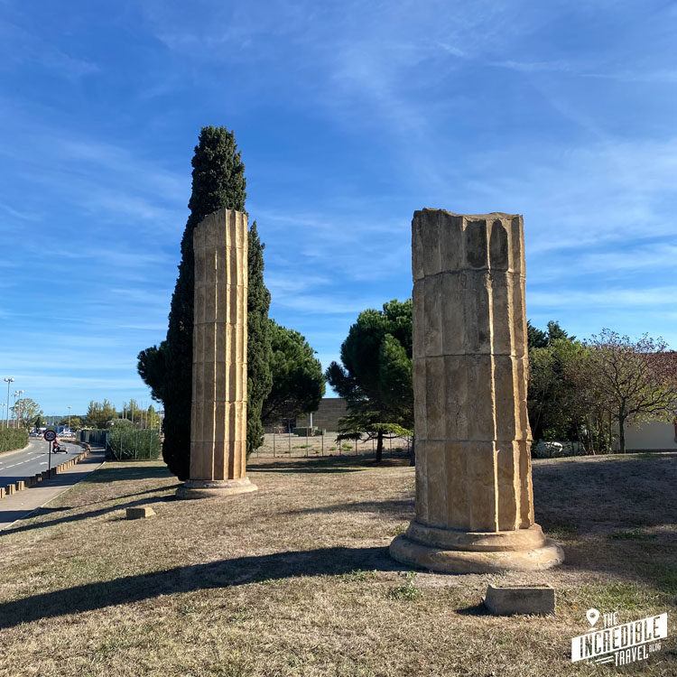 Zwei römische Säulen stehen verlassen an einer Straße