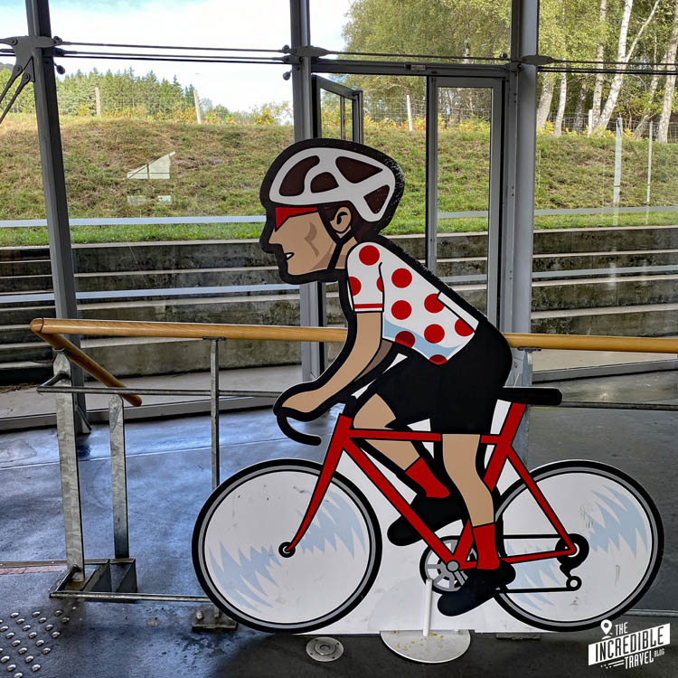 Pappaufsteller einer Comicfigur mit Rennrad und Bergtrikot der Tour de France