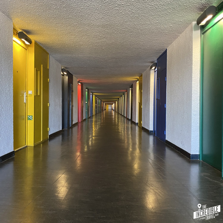 Blick in einen Korridor mit Türen in gelb, blau, grün und rot