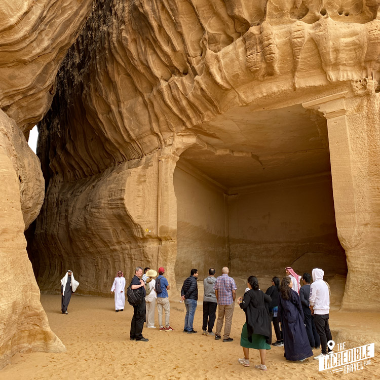 Touristen mit Guide vor einer in den Fels geschlagenen Kammer