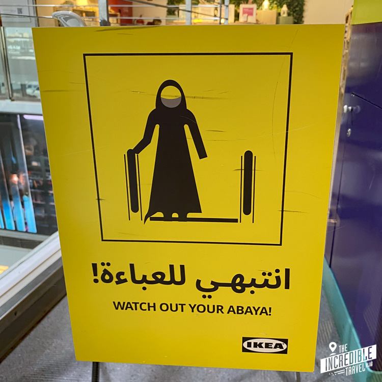 Warnschild an der Rolltreppe, die vor dem Einklemmen der Abaya warnt