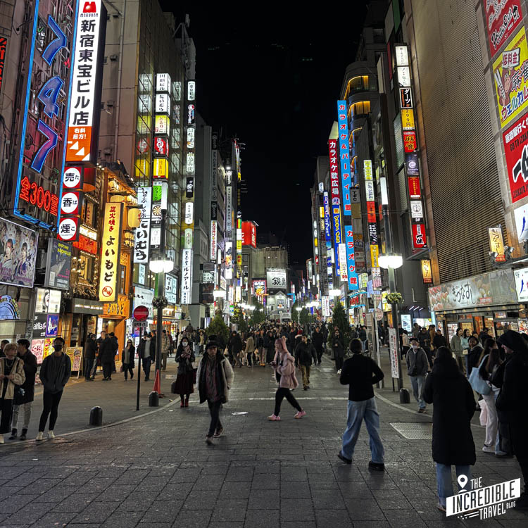 Fußgängerzone in Tokio mit vielen Menschen und Neonreklamen