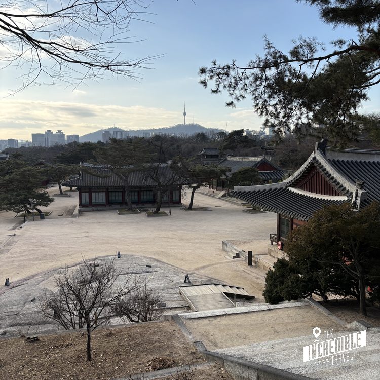 Traditionelle asiatische Tempelanlage mit geschwungenen Dächern in parkähnlicher Landschaft mit modernen Hochhäusern im