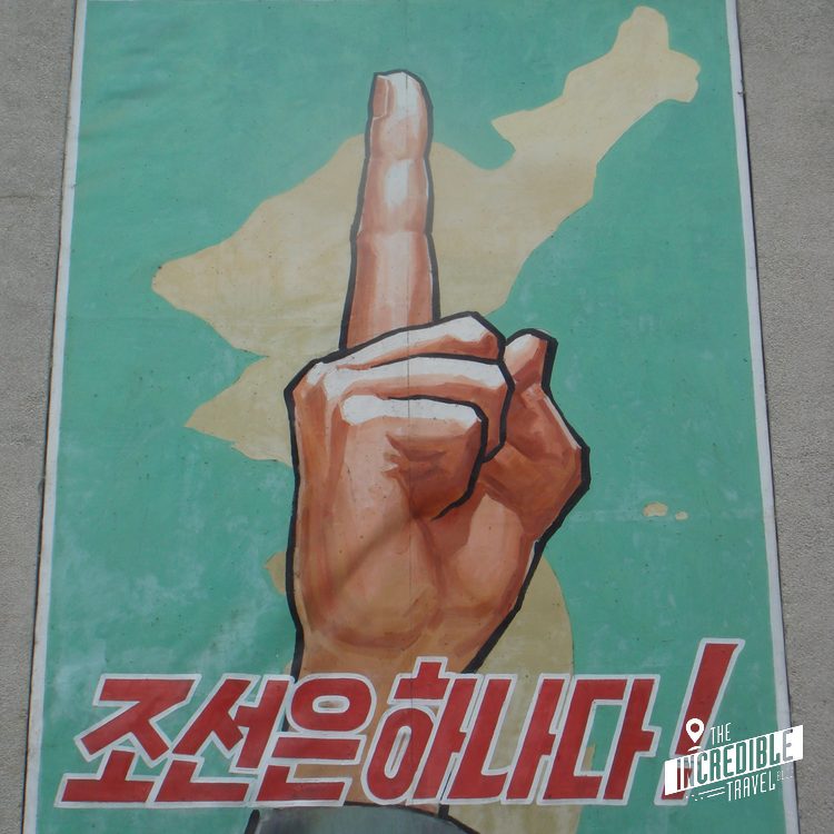 Wandmalerei mit erhobener Faust und Landkarte auf türkisgrünem Hintergrund mit koreanischer Schrift